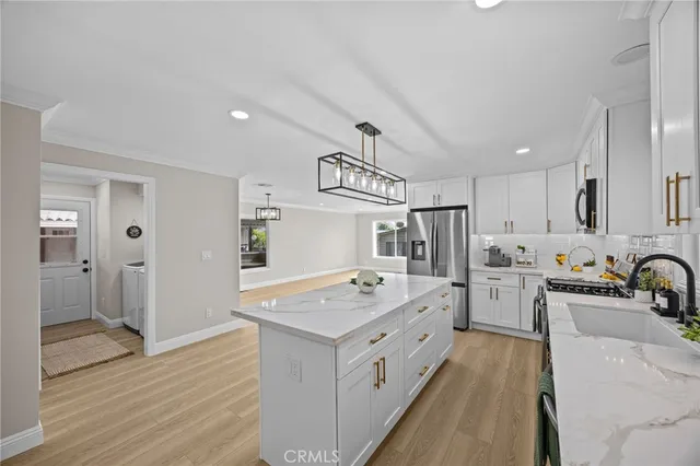 a large white kitchen with a stove a sink a refrigerator and a refrigerator