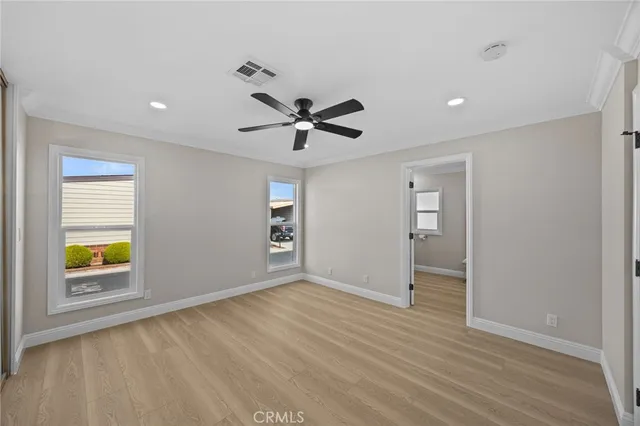 a view of room with wooden floor and ceiling fan