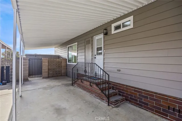 a view of a porch with barbeque and wooden fence