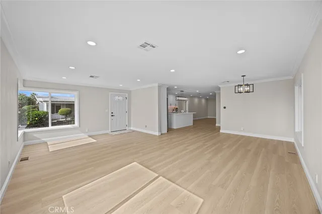 a view of empty room with wooden floor and windows