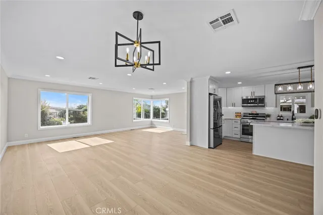a view of kitchen with stainless steel appliances refrigerator and stove top oven