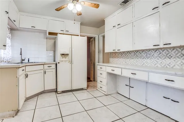 a kitchen with white cabinets and white appliances