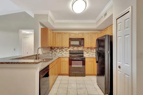 a kitchen with stainless steel appliances granite countertop a refrigerator and a stove top oven