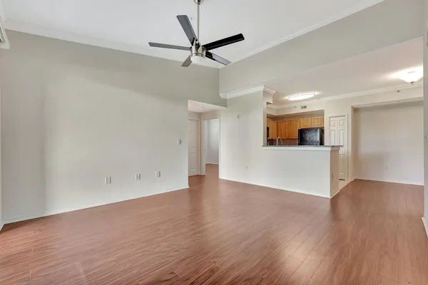a view of a livingroom with a ceiling fan & wooden floor