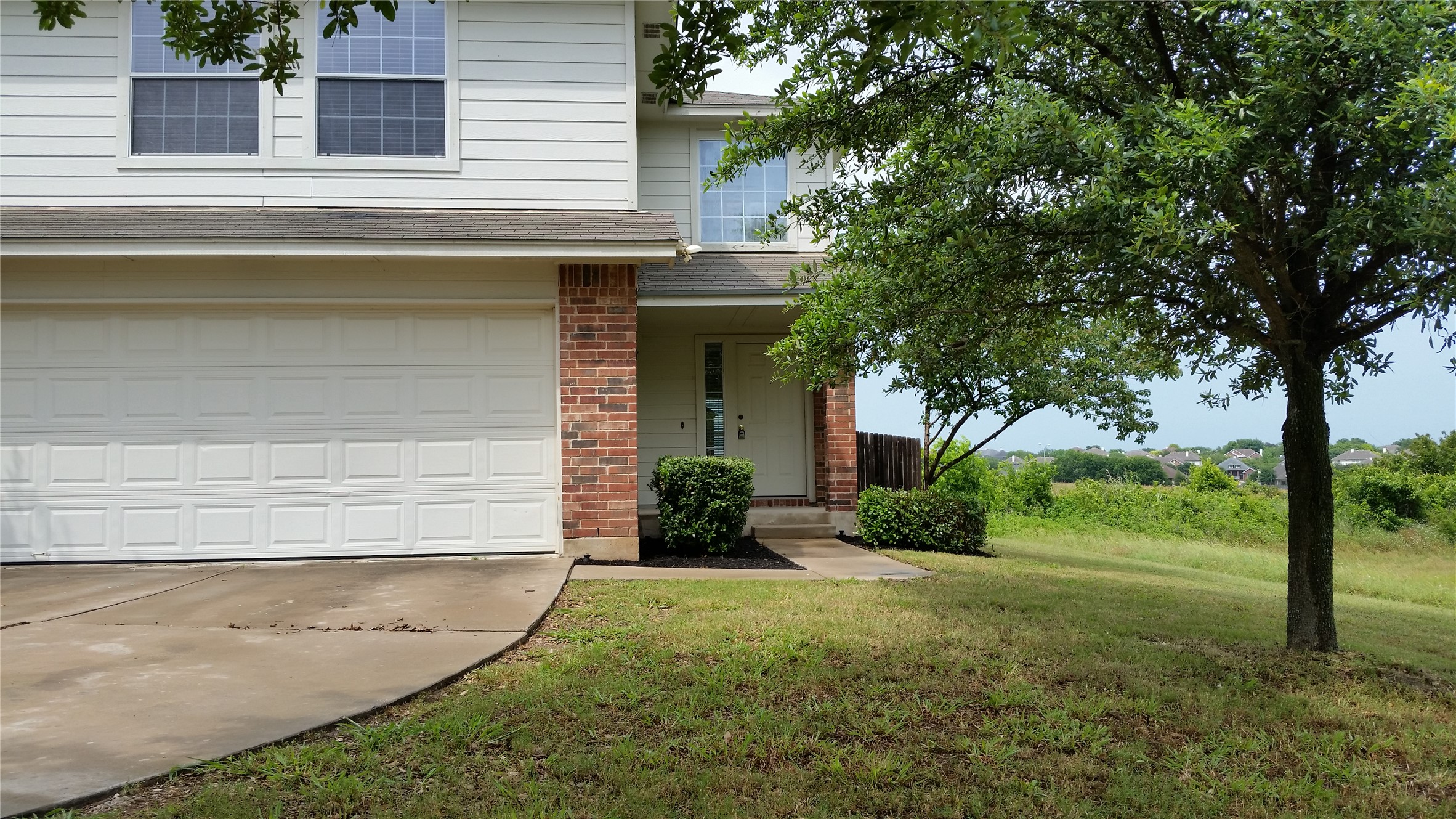 1324 Peppermint Trail Pflugerville, TX 78660 - Photo 2 of 33 View of front facade with brick siding, a front lawn, a porch, concrete driveway, and a garage