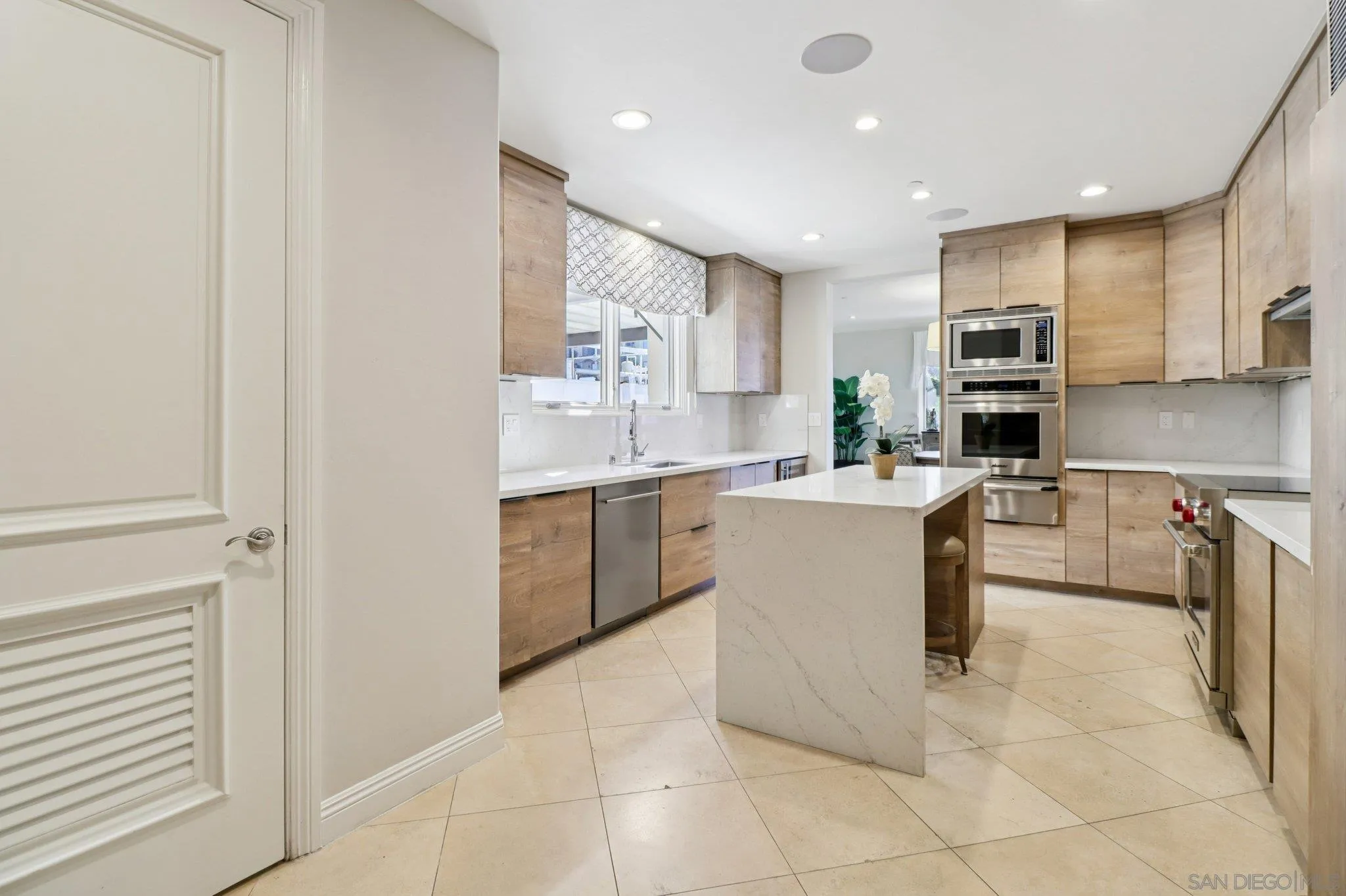 464 Prospect Street, Unit 101 La Jolla, CA 92037 - Photo 17 of 65 a kitchen with a sink a counter top space cabinets and stainless steel appliances