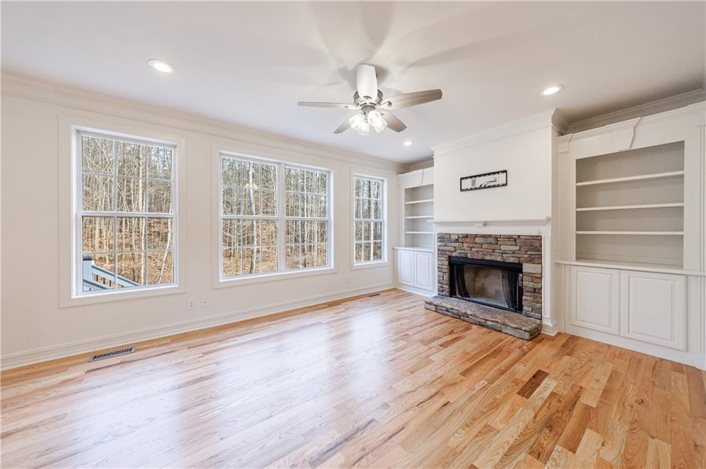 4049 Ashford Way Gainesville, GA 30507 - Photo 22 of 74 a view of an empty room with wooden floor fireplace and a window