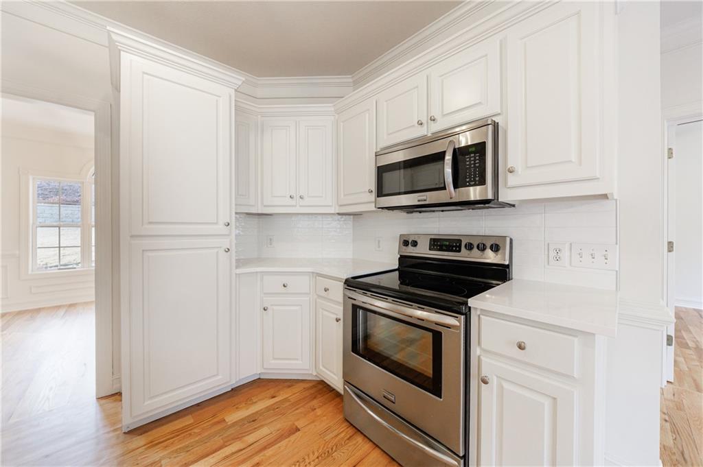 4049 Ashford Way Gainesville, GA 30507 - Photo 33 of 74 a kitchen with stainless steel appliances granite countertop grey cabinets a stove a microwave and a refrigerator