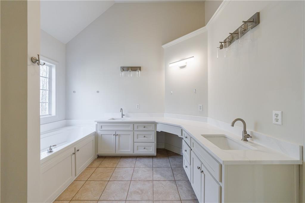 4049 Ashford Way Gainesville, GA 30507 - Photo 47 of 74 a large white bathroom with a double vanity sink a mirror and a bathtub