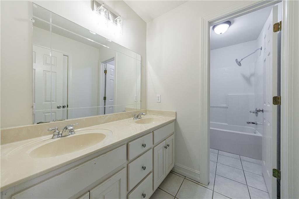 4049 Ashford Way Gainesville, GA 30507 - Photo 56 of 74 a bathroom with a granite countertop sink a mirror and a bathtub