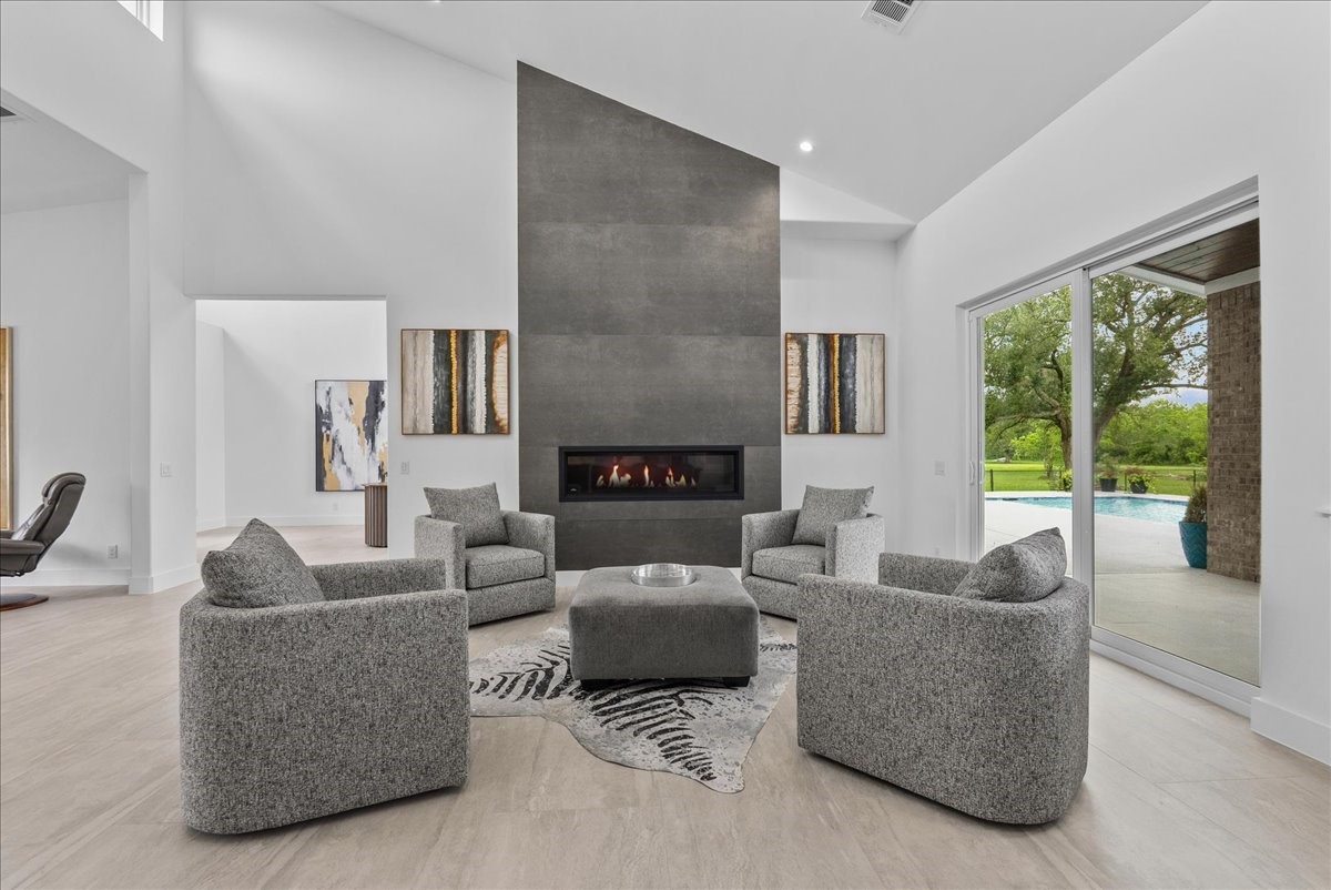 7627 Scott Avenue Manvel, TX 77578 - Photo 15 of 50 The main living area is anchored by a floor-to-ceiling modern fireplace flanked with imported Italian tile and soaring vaulted ceilings.