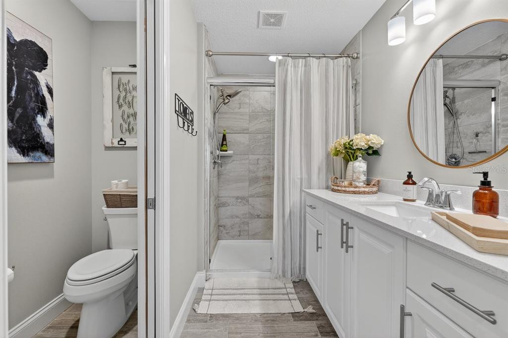 3417 Gallia Street New Smyrna Beach, FL 32168 - Photo 37 of 52 a bathroom with a granite countertop sink a toilet and shower