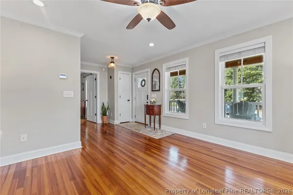 a kitchen with stainless steel appliances granite countertop a refrigerator a sink dishwasher a stove and a dining table with wooden floor