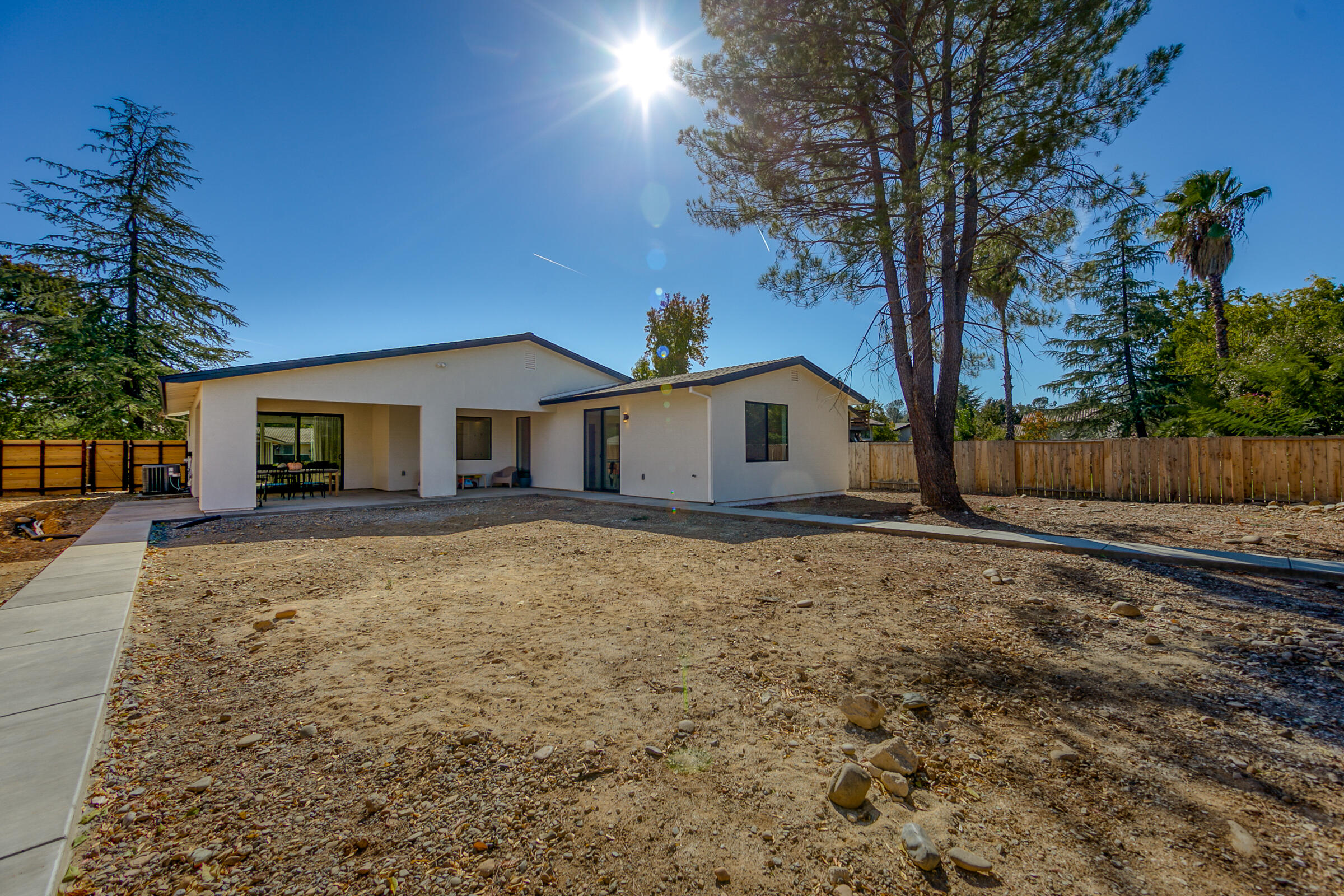 288 Tourmaline Way Redding, CA 96003 - Photo 37 of 46 a backyard of a house with wooden fence and large trees