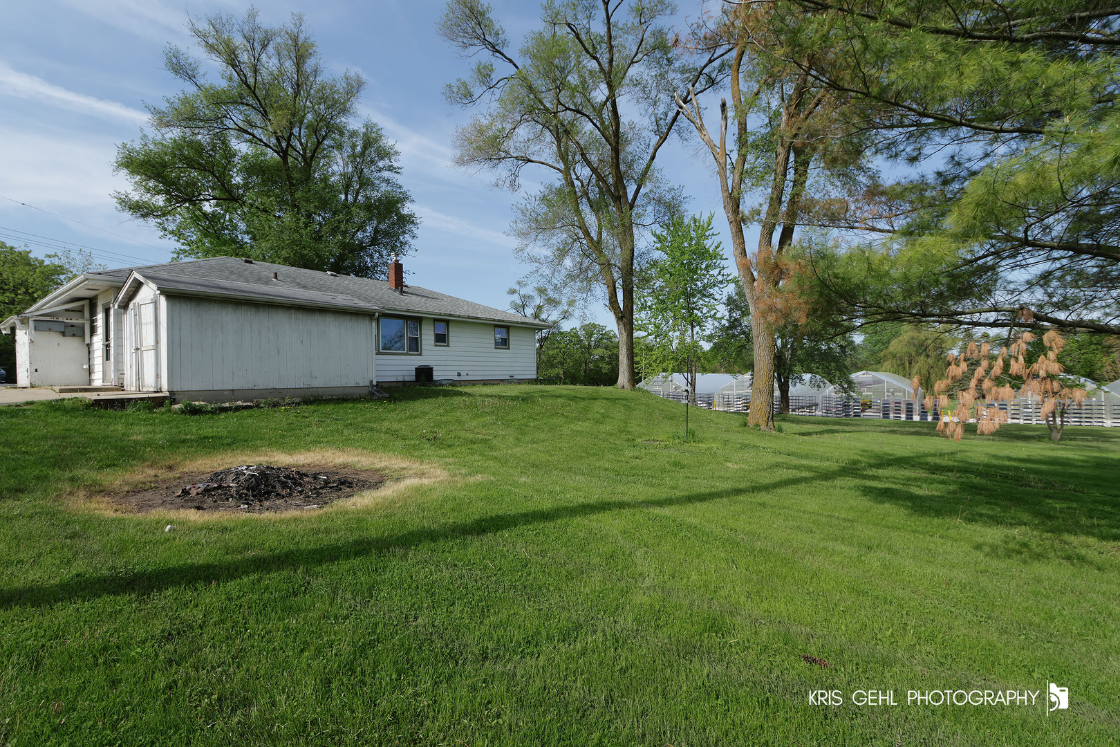 24260 Town Line Road Lake Villa, IL 60046 - Photo 19 of 20 a view of a white house with a big yard and potted plants and large trees