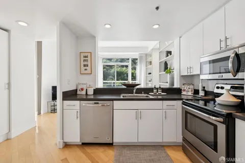 a kitchen with stainless steel appliances a sink stove and cabinets