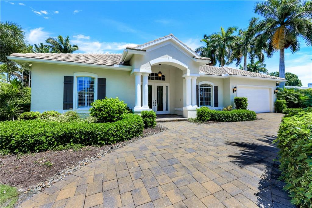425 Rudder Road Naples, FL 34102 - Photo 1 of 31 a front view of a house with a garden