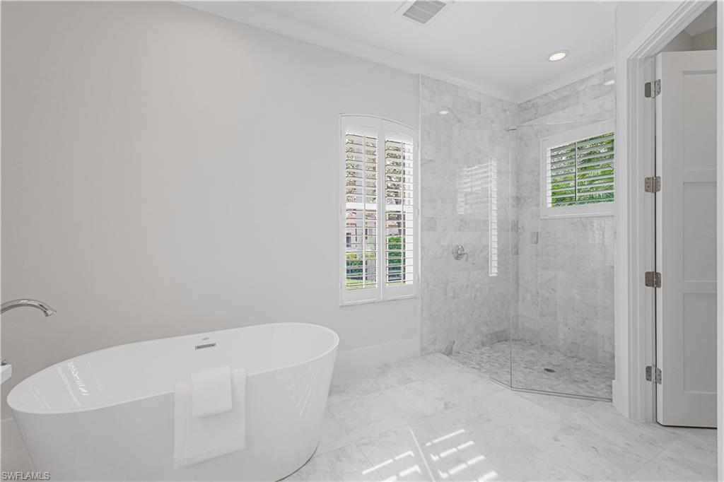 425 Rudder Road Naples, FL 34102 - Photo 15 of 31 a bathroom with a bathtub and shower