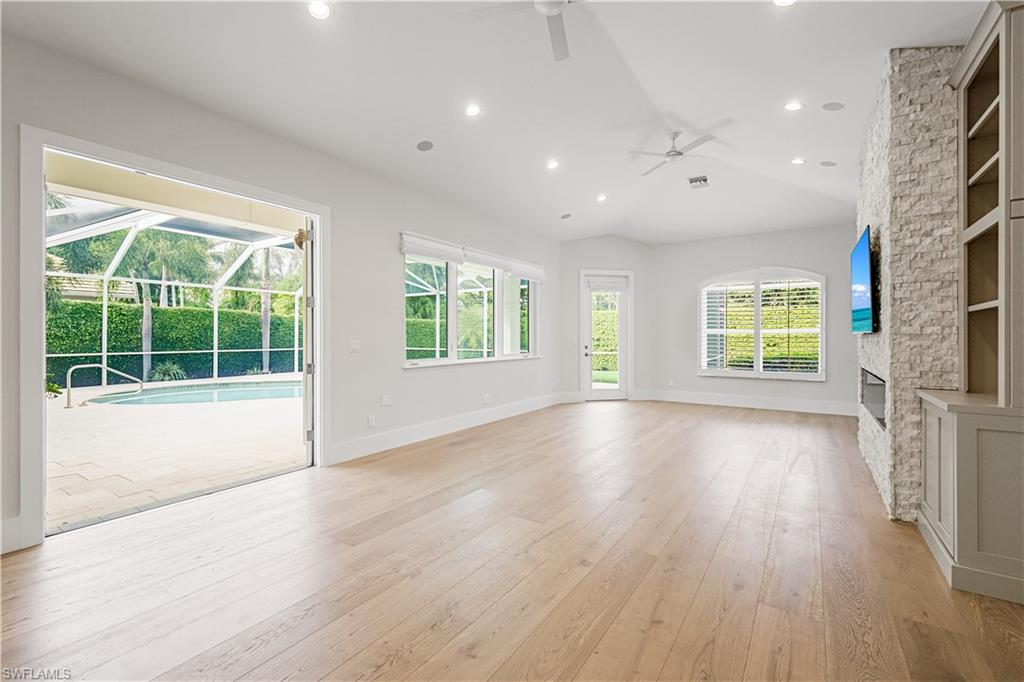 425 Rudder Road Naples, FL 34102 - Photo 20 of 31 a view of an empty room with wooden floor and a window