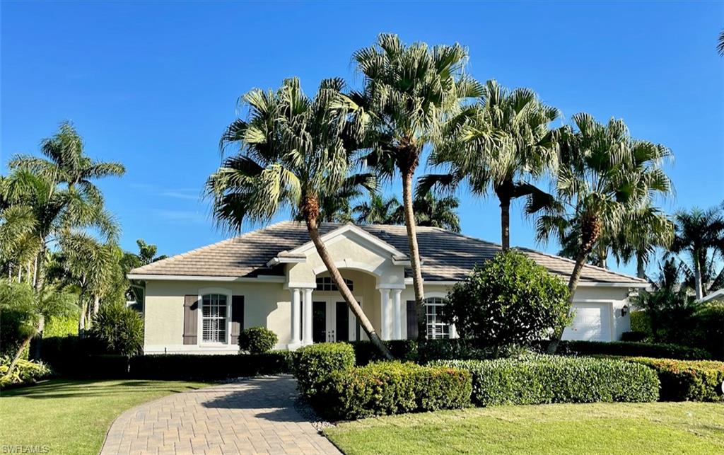 425 Rudder Road Naples, FL 34102 - Photo 2 of 31 a front view of a house with a garden