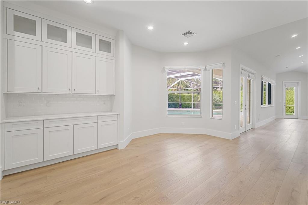 425 Rudder Road Naples, FL 34102 - Photo 22 of 31 a view of an empty room with a window and wooden floor