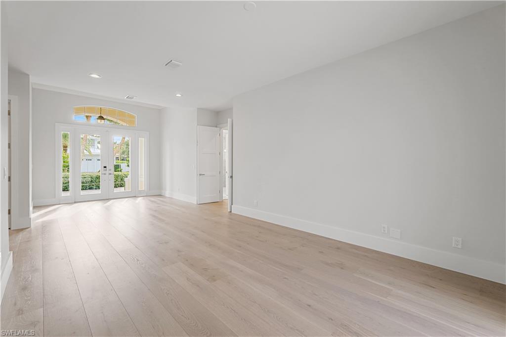 425 Rudder Road Naples, FL 34102 - Photo 23 of 31 an empty room with wooden floor and windows