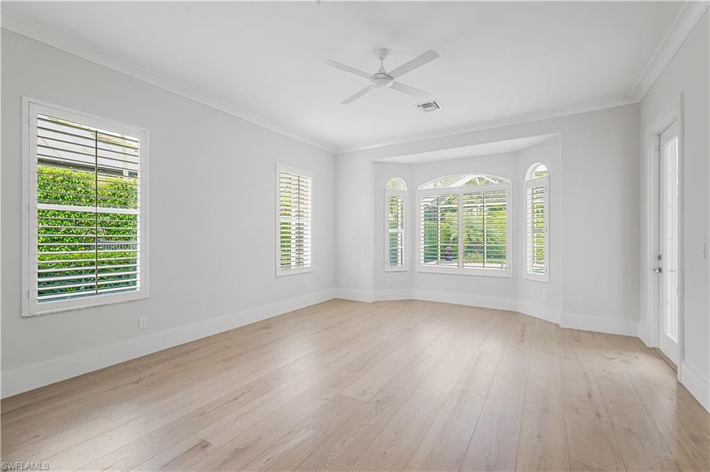 425 Rudder Road Naples, FL 34102 - Photo 24 of 31 a view of an empty room with wooden floor and a window