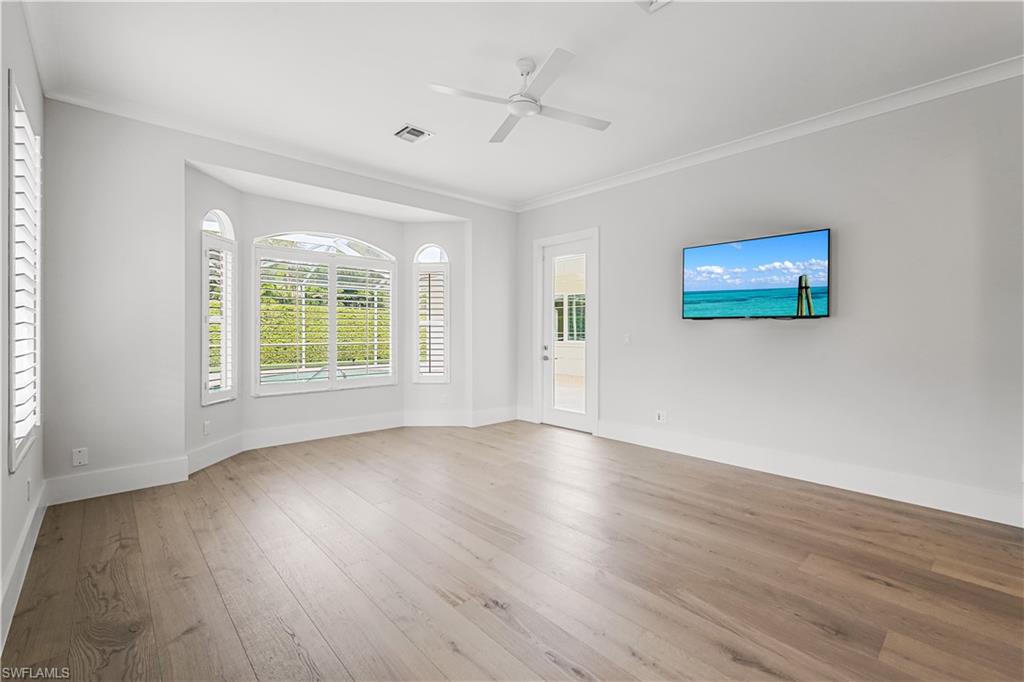 425 Rudder Road Naples, FL 34102 - Photo 25 of 31 an empty room with wooden floor and windows