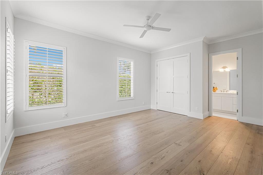 425 Rudder Road Naples, FL 34102 - Photo 26 of 31 an empty room with wooden floor and windows
