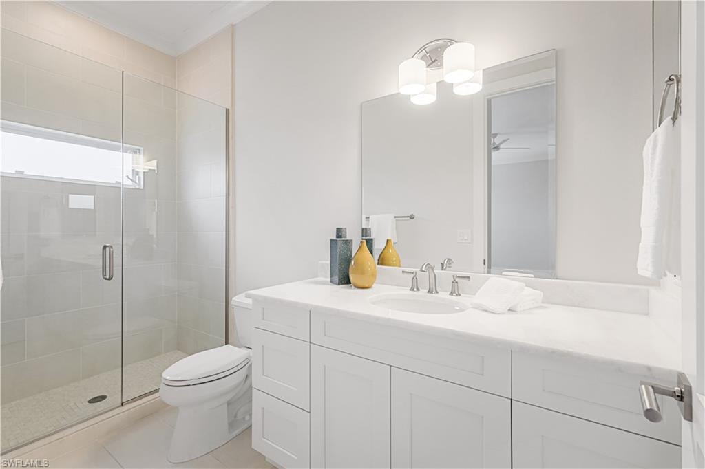425 Rudder Road Naples, FL 34102 - Photo 27 of 31 a bathroom with a sink a toilet and shower