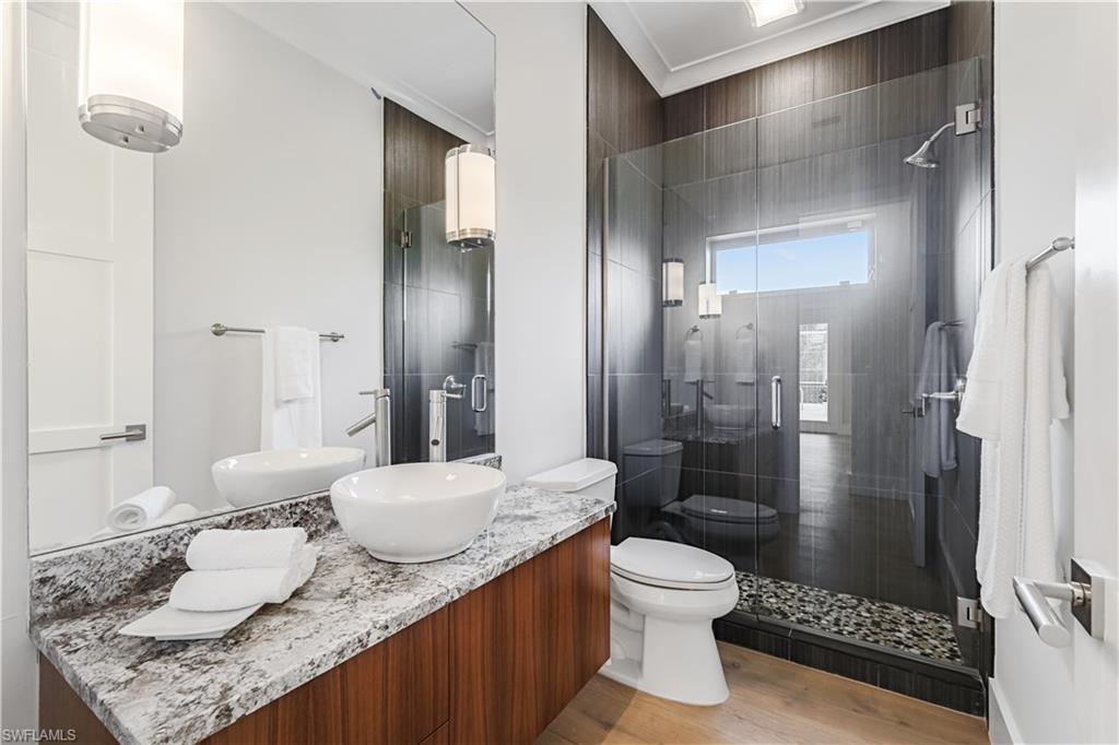 425 Rudder Road Naples, FL 34102 - Photo 28 of 31 a bathroom with a granite countertop sink a toilet and shower