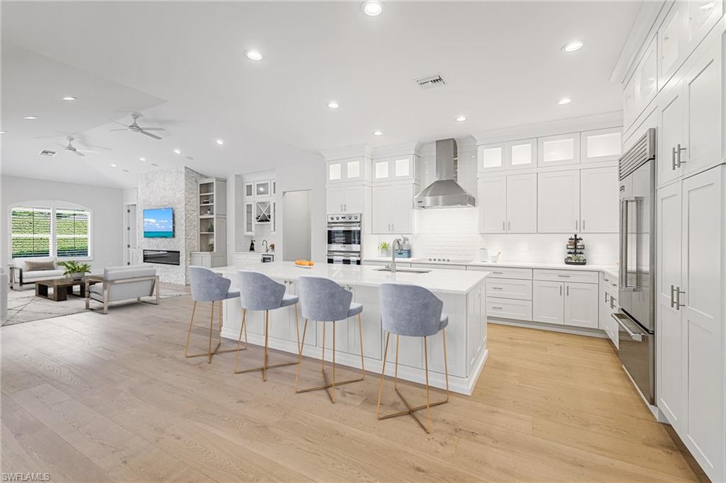 425 Rudder Road Naples, FL 34102 - Photo 5 of 31 an open kitchen with white cabinets and stainless steel appliances