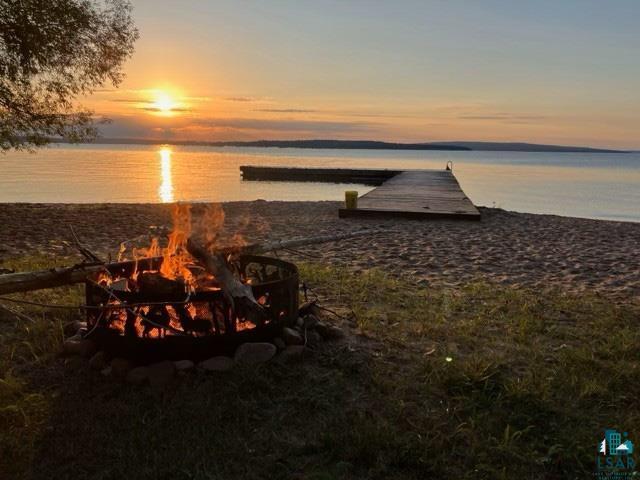 3346 Stockton Road La Pointe, WI 54850 - Photo 51 of 51 Waterfront property featuring a private sandy beach, an installed fire pit, and a wooden dock extending into the water