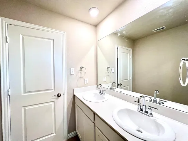 a bathroom with a double vanity sink and a mirror