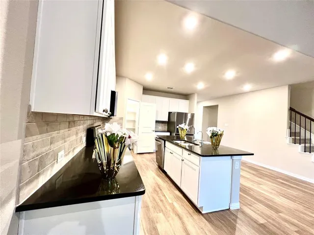 a kitchen with counter top space a sink and appliances
