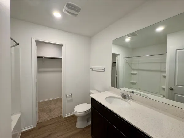 a bathroom with a sink a toilet and a large mirror