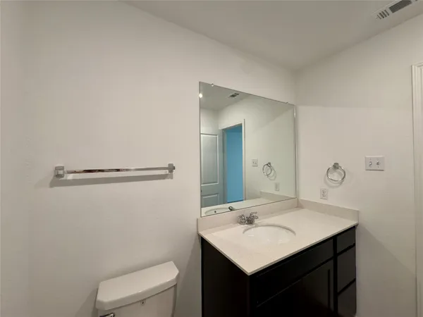 a bathroom with a sink a toilet a mirror and vanity