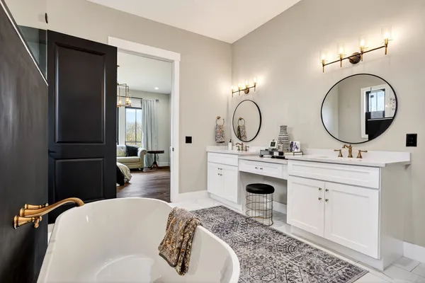a en suite bathroom with a granite countertop double vanity sink and a mirror