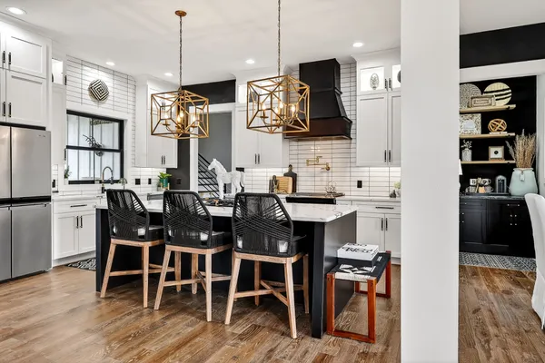 a kitchen with stainless steel appliances granite countertop a sink and a refrigerator