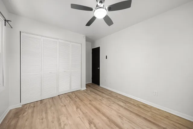 a view of empty room with wooden floor