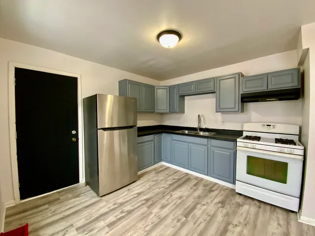 a kitchen with stainless steel appliances granite countertop a refrigerator a stove and a sink