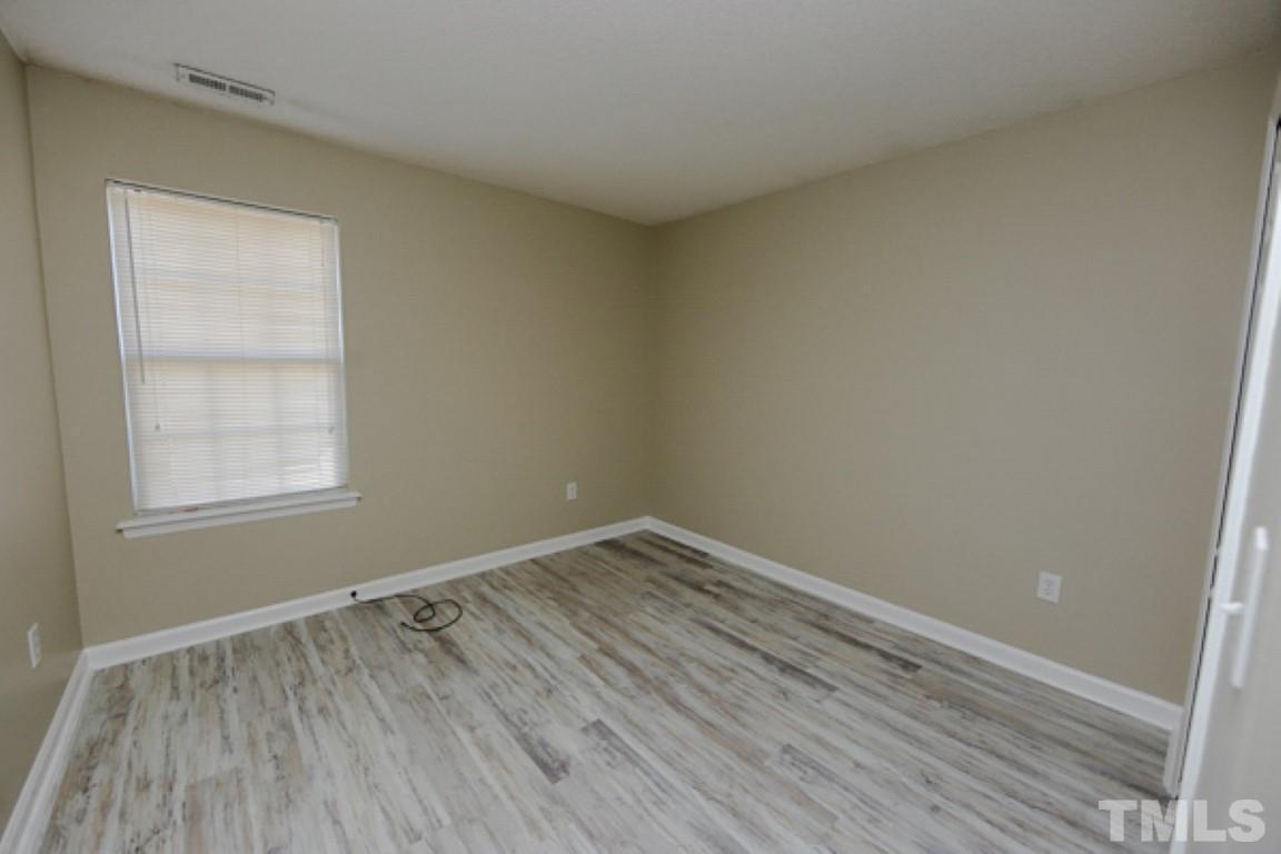 608 Edenberry Drive Durham, NC 27713 - Photo 12 of 14 an empty room with wooden floor and windows