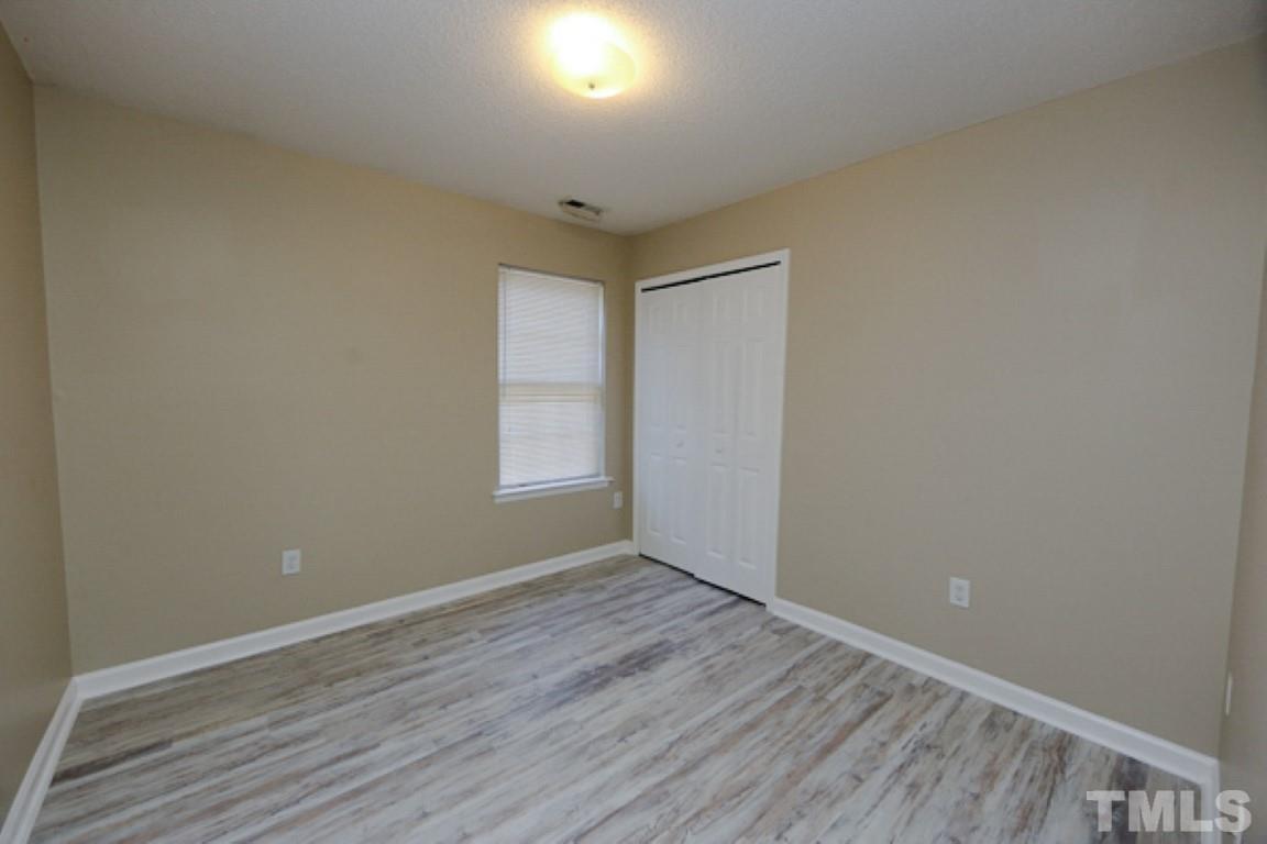 608 Edenberry Drive Durham, NC 27713 - Photo 10 of 14 an empty room with wooden floor and windows