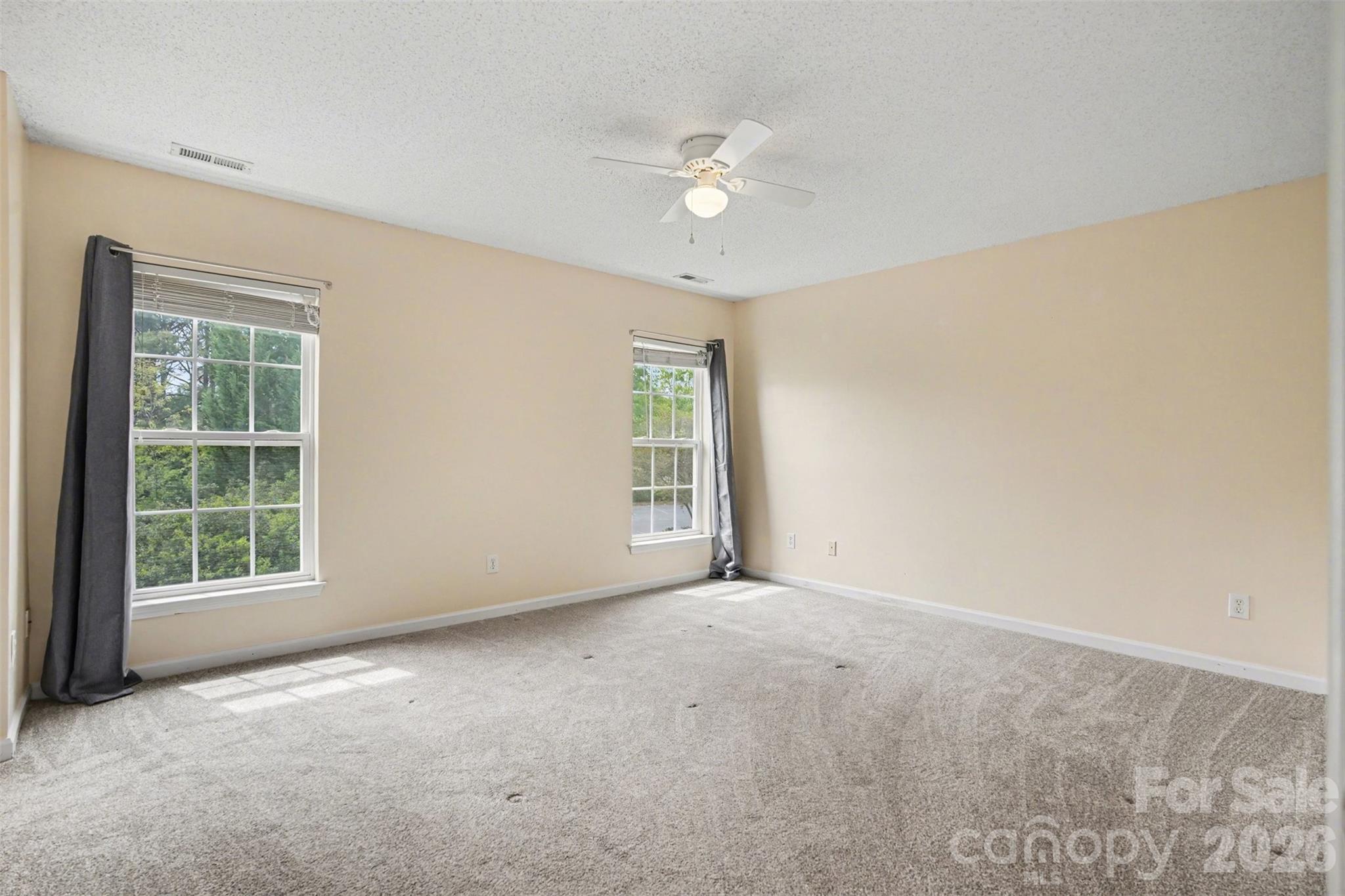 3315 Summerfield Ridge Lane Matthews, NC 28105 - Photo 13 of 27 an empty room with windows and chandelier fan