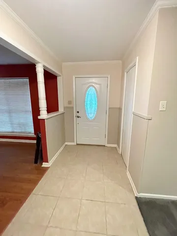 a view of an empty room with window and hardwood floor