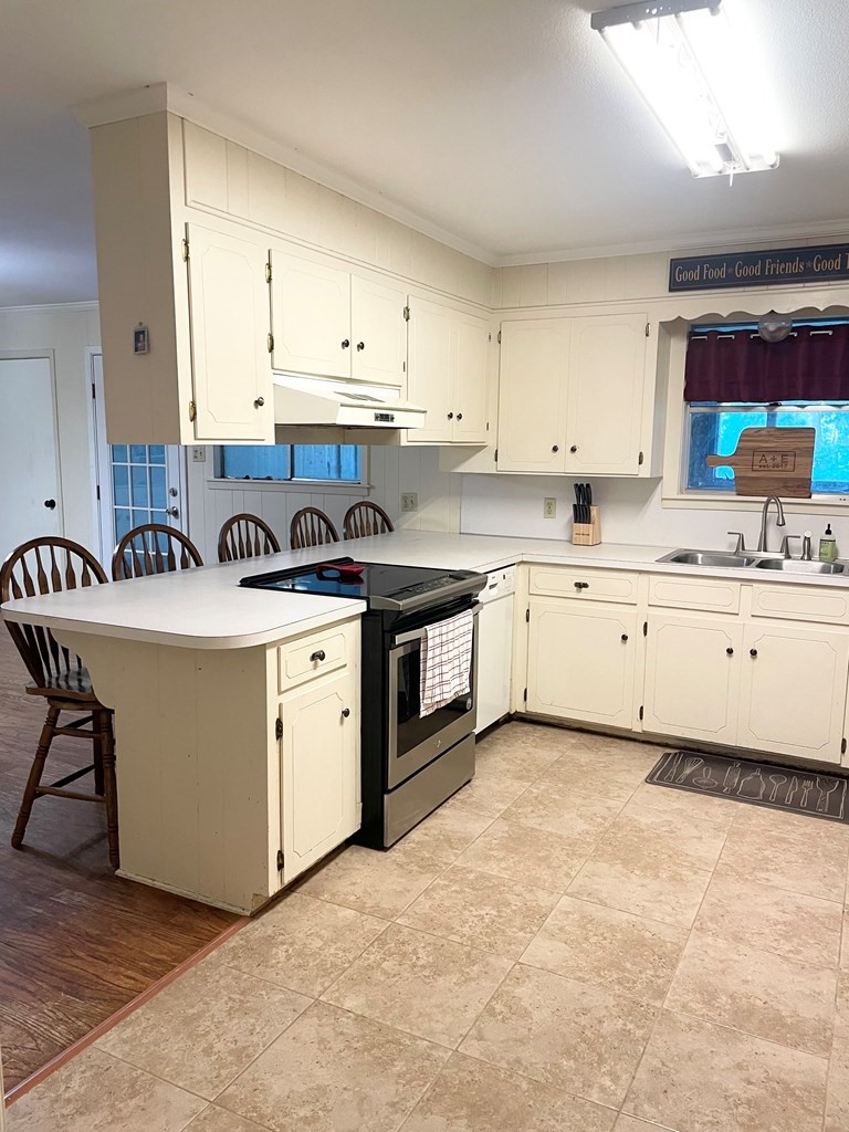 807 El Camino Road Grapeland, TX 75844 - Photo 10 of 34 a kitchen with a stove top oven sink and cabinets