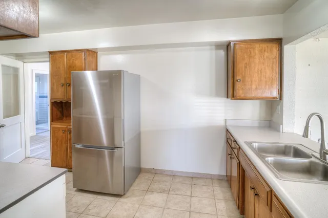 a kitchen with a refrigerator sink and cabinets