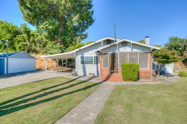 a front view of a house with a yard table and chairs