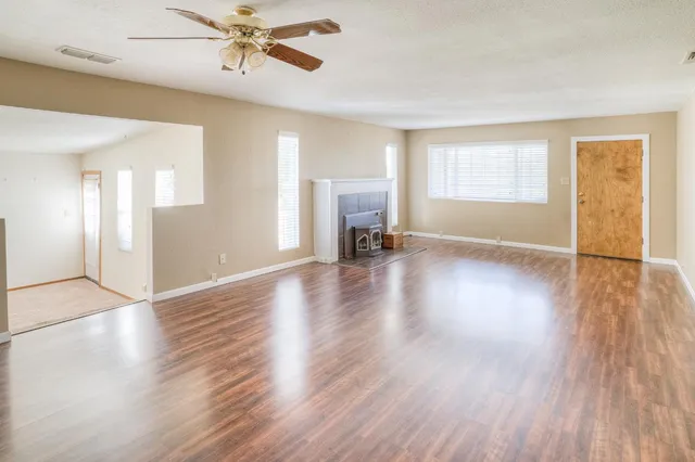 a view of a livingroom with wooden floor and a ceiling fan
