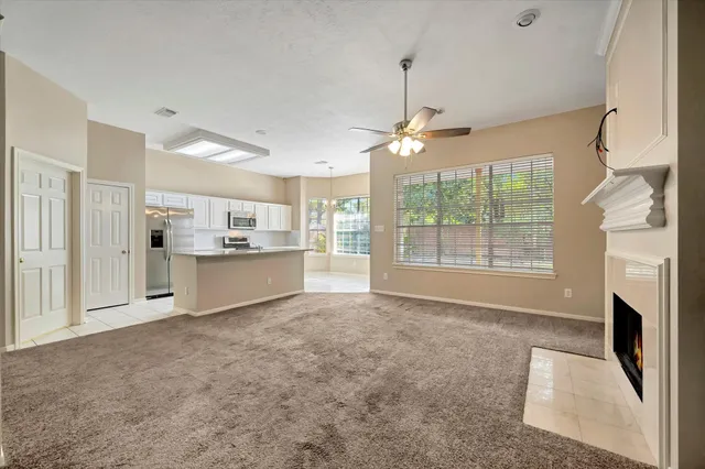 a view of an empty room with a fireplace and a window